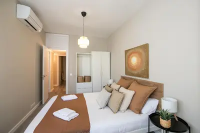 a bedroom with a white couch with pillows at Eixample Barcelona Luxury for 8 in Barcelona