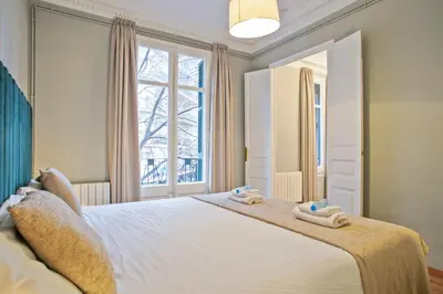a bedroom with a large white bed with towels on it at Alcam Entenza in Barcelona