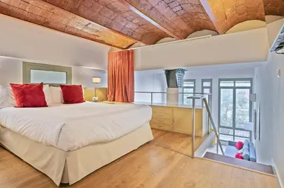 a bedroom with a large bed with red pillows at Alcam Paseo de Gracia in Barcelona