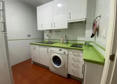 a white kitchen with a washing machine in it at Cristina in Arenys de Mar