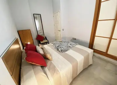 a bedroom with a large bed with red pillows at Cristina in Arenys de Mar