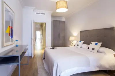 a bedroom with a large white bed and a desk at Ola Living Broto in Barcelona