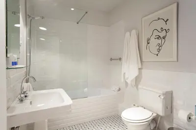 a white bathroom with a toilet and a sink at Ola Living Broto in Barcelona