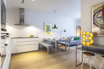 a kitchen and living room with a table and a couch at Ola Living Broto in Barcelona