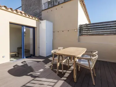 a wooden table and chairs sitting on a balcony at 'The Residences At Bartomeu 26 ' Suite Benazet in Sitges
