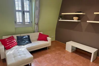 a living room with a white couch with red and blue pillows at NEW! Apartment for 4 people near the beach in Poblenou in Barcelona