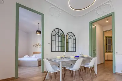 a dining room with a table and chairs and a bed at Modernist Apartment 2 in Barcelona