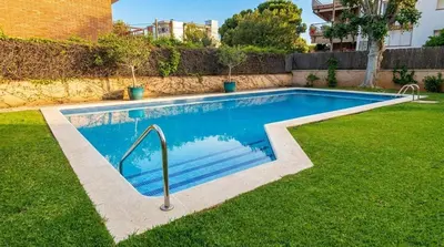 a small swimming pool in a yard with a grass field at Apart Villa Cristina 5 min walk to the beach RoofTop Duplex 180 M2 Very Cared in Sitges