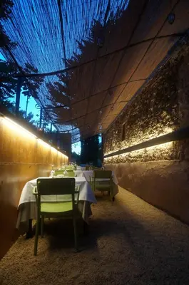 a dining room with tables and chairs with blue lights at Hotel Can Ribalta in San Antonio de Vilamajor