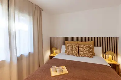 a bedroom with a bed with two mugs on a tray at Lodging Apartments Besos River 11 in Santa Coloma