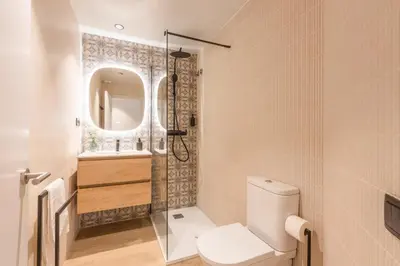 a bedroom with a large bed with a tropical wallpaper at Lodging Apartments Besos River B1 in Santa Coloma