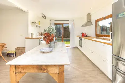 a kitchen with a wooden table in the middle at Casa con encanto a los pies del Montseny in La Batlloria
