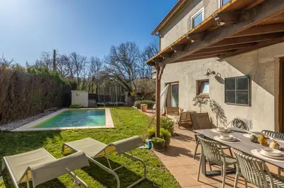 a patio with a table and chairs and a swimming pool at Casa con encanto a los pies del Montseny in La Batlloria