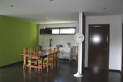 a kitchen and dining room with a table and a clock at Casa ceca de la Playa y Barcelona, con piscina climatizada y jacuzzi in Vallromanas