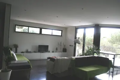 a living room with a couch and a tv at Casa ceca de la Playa y Barcelona, con piscina climatizada y jacuzzi in Vallromanas