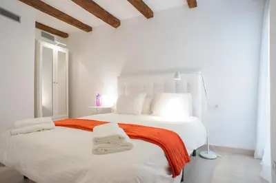 a white bedroom with a large bed with towels on it at Casa De Poble Termes Romanes in Caldes de Montbui