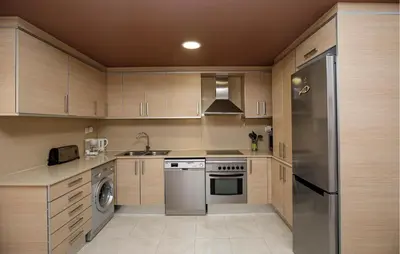 a kitchen with wooden cabinets and a stainless steel refrigerator at Beautiful Apartment In Pineda De Mar in Pineda de Mar