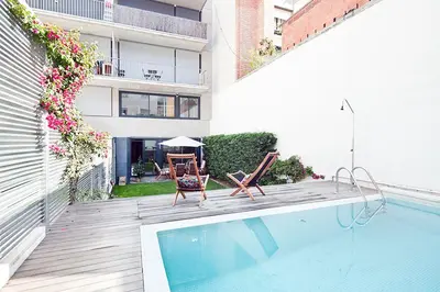 a balcony with a pool and chairs and a building at My Space Barcelona Private Pool Garden in Barcelona