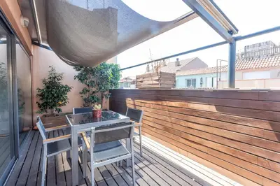 a balcony with a table and chairs on a wooden deck at My Space Barcelona Penthouse Terrace in Barcelona