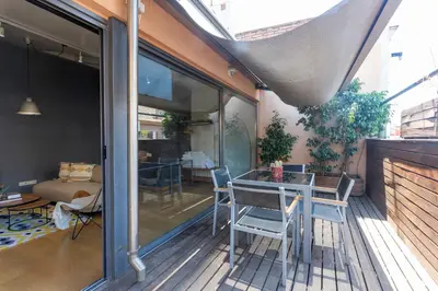 a patio with a table and chairs on a deck at My Space Barcelona Penthouse Terrace in Barcelona