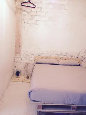 a bed in a room with a brick wall at Apartments San Ignacio de Loyola in Manresa