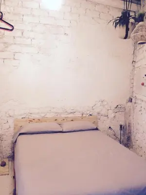 a bed in a room with a white brick wall at Apartments San Ignacio de Loyola in Manresa