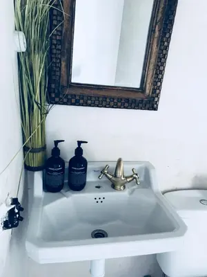 a bathroom sink with a mirror and two soap bottles at Apartments San Ignacio de Loyola in Manresa
