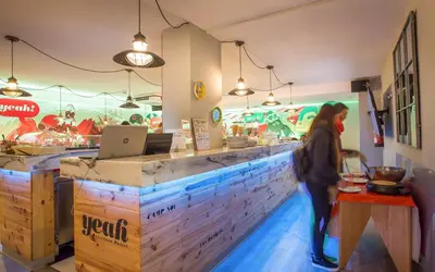 a woman standing at a counter in a restaurant at Yeah Barcelona Hostel in Barcelona