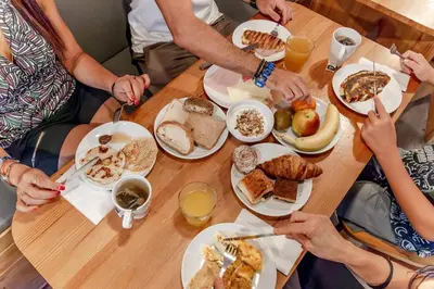a group of people sitting around a table eating breakfast at Yeah Barcelona Hostel in Barcelona