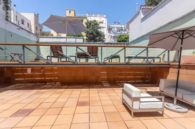 a patio with tables and chairs and an umbrella at My Space Barcelona Gracia Pool Terrace in Barcelona