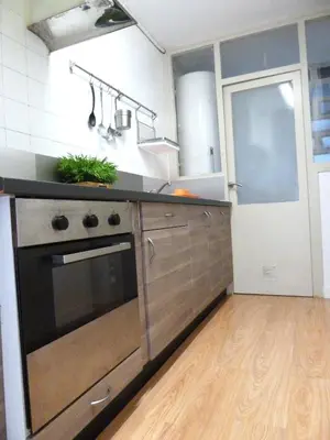 a kitchen with a stainless steel oven and wooden cabinets at Joanic Apartment Escorial in Barcelona