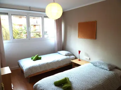 a room with two twin beds and a window at Joanic Apartment Escorial in Barcelona