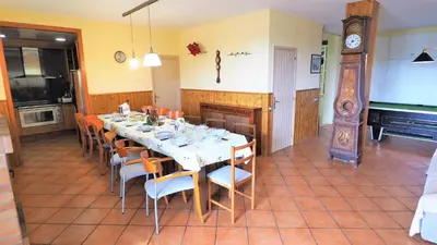 a dining room with a long table with chairs and a piano at Villa Carolina in Mataró