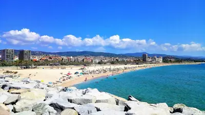 a group of people on a beach near the water at Villa Carolina in Mataró