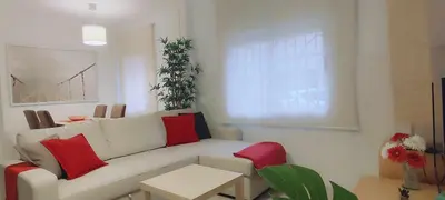 a living room with a white couch and red pillows at Maria House. in Viladecáns