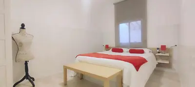 a white bedroom with a bed and a table at Maria House. in Viladecáns