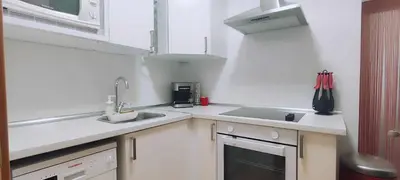a kitchen with white counters and a sink and a window at Maria House. in Viladecáns