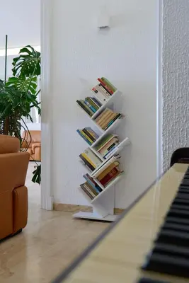 a book shelf filled with books next to a piano at Hotel Miramar Badalona in Badalona