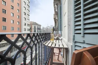 a balcony with a table with wine glasses on it at Alcam Trafalgar in Barcelona