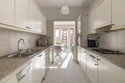 a kitchen with white cabinets and a sink at Stay U-nique Apartments Salvador Espriu in Barcelona