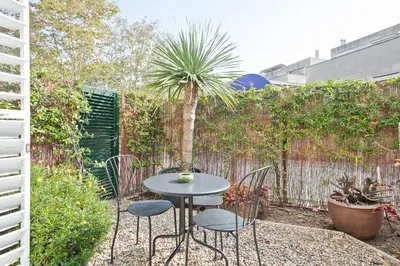 a patio with a table and chairs and a palm tree at Alcam Olimpic in Barcelona
