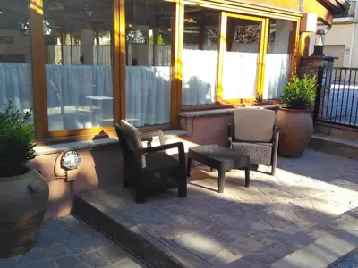 a patio with two chairs and a table and a bench at Hotel Can Missé in Collbató