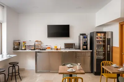 a kitchen with a bar with a tv on the wall at Hostal Baler in Barcelona