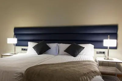 a bedroom with a large bed with a blue headboard at MH Apartments Tetuan in Barcelona