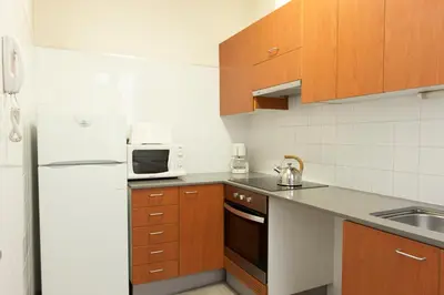 a kitchen with wooden cabinets and a white refrigerator at MH Apartments Tetuan in Barcelona