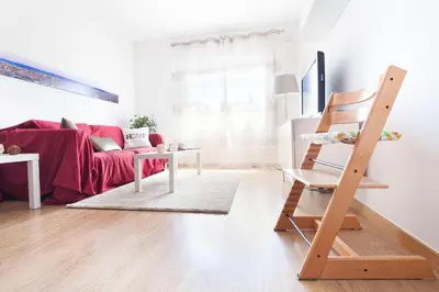 a living room with a red couch and a wooden ladder at Luxury Apartment Barcelona in Barcelona