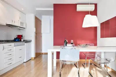 a kitchen with a white table and a red wall at Luxury Apartment Barcelona in Barcelona
