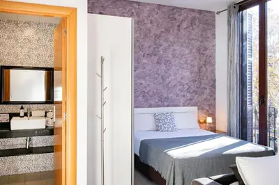 a bedroom with a bed and a sink and a mirror at Aparthotel Rambla108 in Barcelona