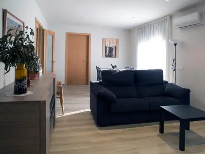 a living room with a blue couch and a table at Cal Negri in Vilafranca del Penedès