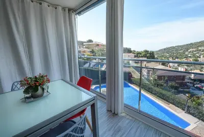 a balcony with a table and a view of a pool at Apartamento Reisol in Castelldefels